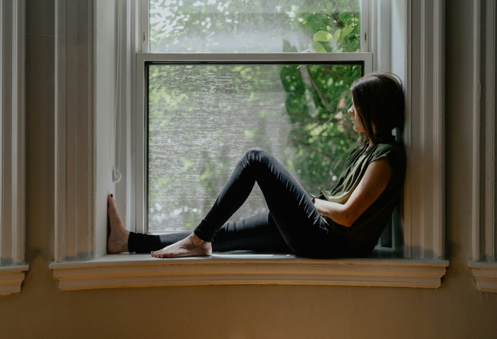 Woman sitting thoughtfully by a window