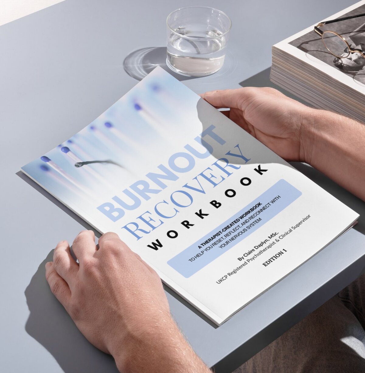 Hands opening the Burnout Recovery Workbook